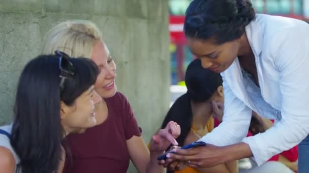 Vrouwelijke vrienden kijken naar mobiele telefoon — Stockvideo