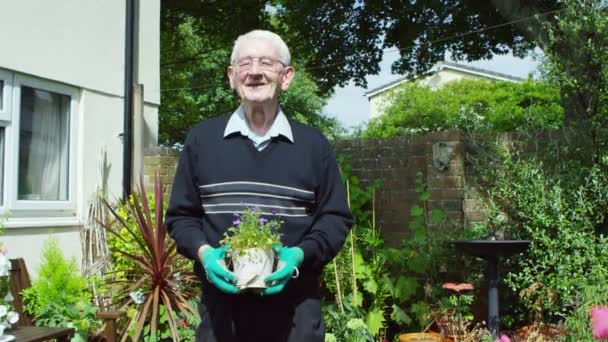 Άντρας που κρατάει μια γλάστρα με λουλούδια — Αρχείο Βίντεο