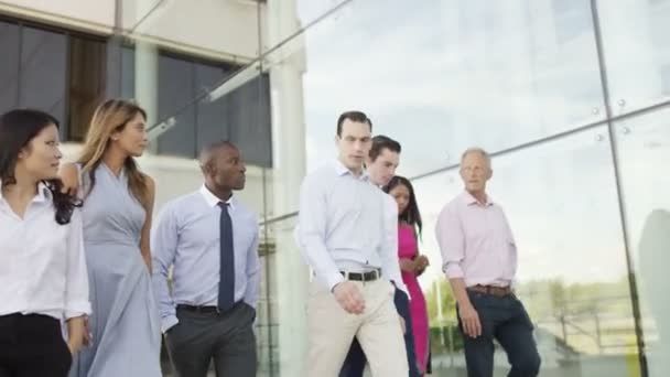 Equipo de negocios caminar fuera del edificio de oficinas — Vídeo de stock