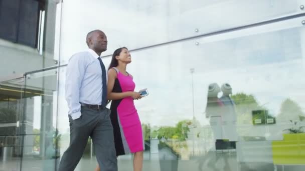 Hombre y mujer de negocios caminar fuera de la oficina — Vídeo de stock