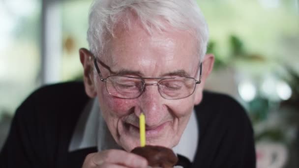 Anciano sopla una vela en torta de la taza — Vídeo de stock