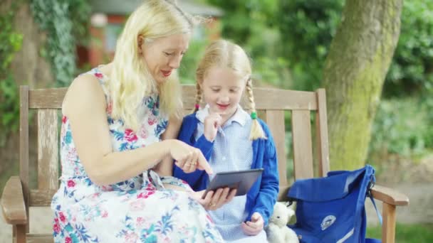 Mädchen mit Mutter schaut auf Tablet — Stockvideo