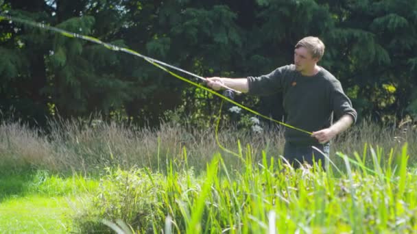 Человек ловит рыбу на озере — стоковое видео