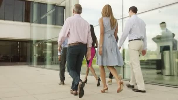 Equipo de negocios caminando fuera del edificio de oficinas — Vídeos de Stock