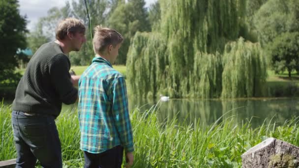 Manusia dan anak memancing di danau — Stok Video