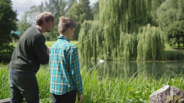 Manusia dan anak memancing di danau — Stok Video