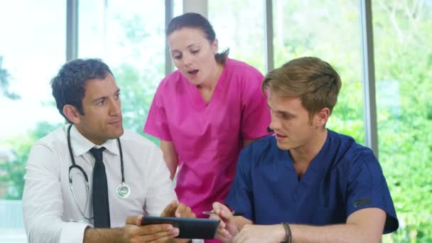 Ärzteteam schaut sich Computer-Tablet an — Stockvideo