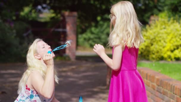 Meisje met moeder spelen met bubbels — Stockvideo