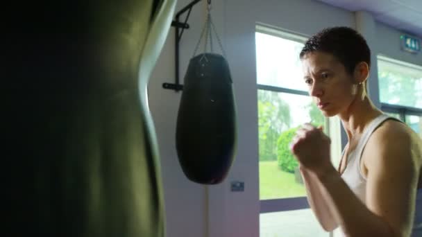 Entrenamiento de boxeador con un saco de boxeo — Vídeos de Stock