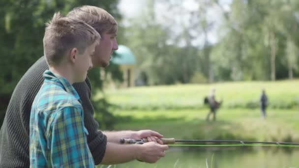 Hombre y niño pescando en el lago — Vídeos de Stock