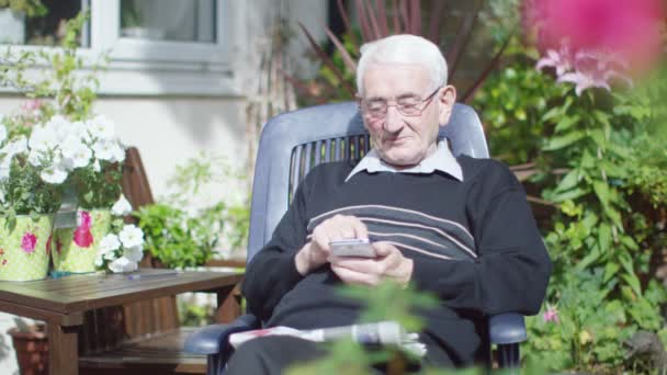 Anciano hombre mensajes de texto en el teléfono móvil — Vídeo de stock