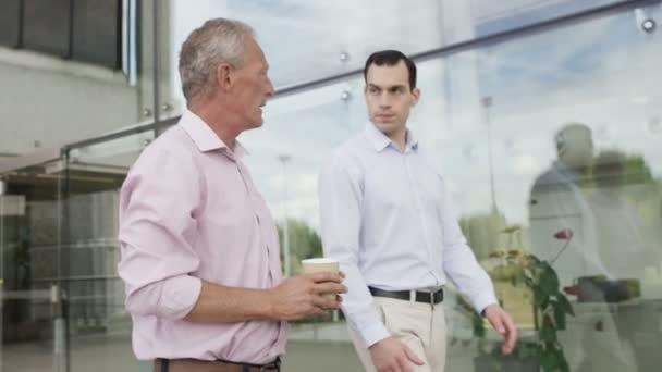 Businessmen in conversation walk outside office — Stock Video