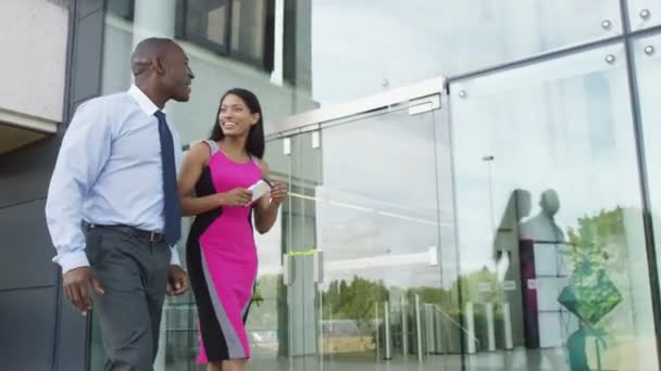 Business man and woman walk outside office — Stock Video