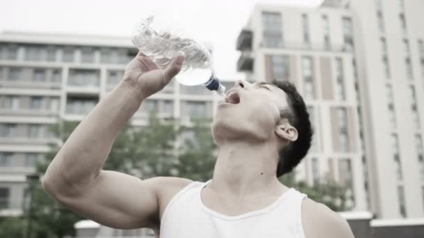 El hombre se toma un descanso para rehidratarse con agua — Vídeos de Stock