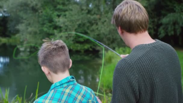 Hombre y niño pescando en el lago — Vídeo de stock