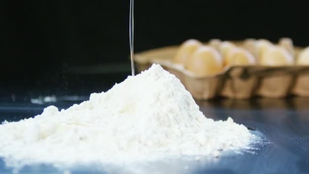 Fresh egg falling into a heap of flour — Stock Video