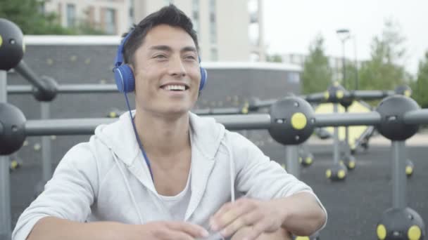Asiatischer Mann trägt Kopfhörer — Stockvideo