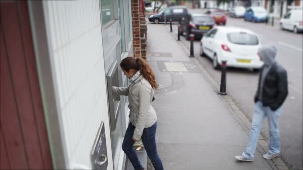 Maschio a seguito di una donna che ha preso contanti — Video Stock