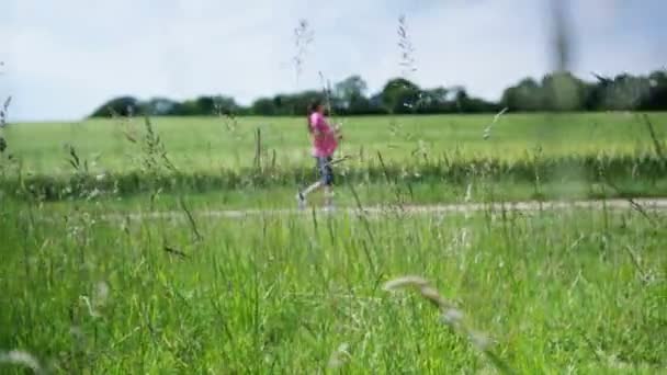 Mujer caminando en el campo — Vídeo de stock