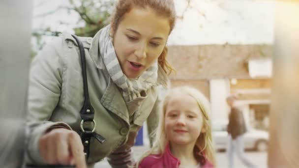 Vrouw met dochter neemt geld uit de ATM-machine — Stockvideo