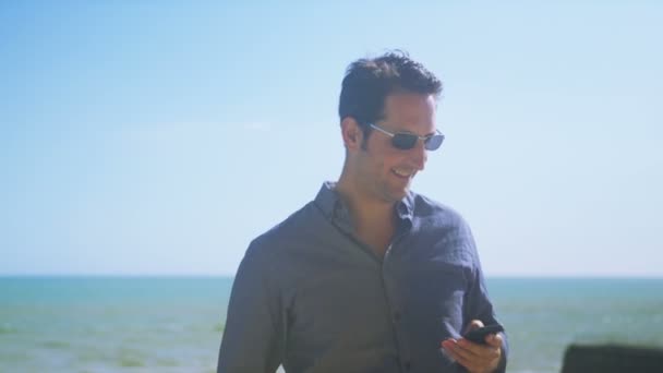 Man met mobiele telefoon op het strand — Stockvideo