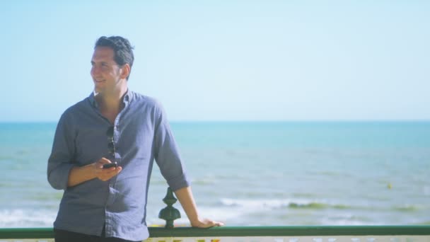 Homem com telefone celular na praia — Vídeo de Stock