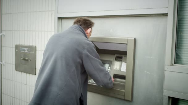 Человек берет наличные из банкомата — стоковое видео