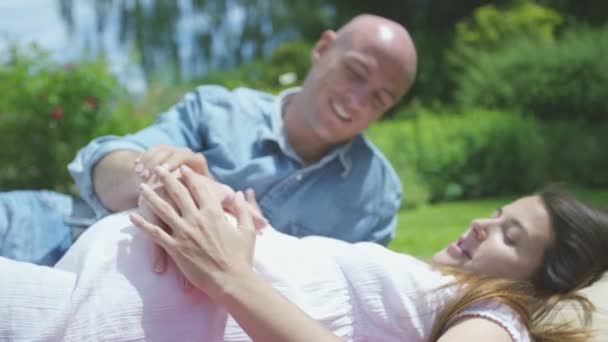Пара ожидает ребенка с руками на животе — стоковое видео