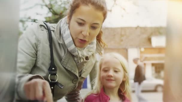 Kvinne med datter tar penger fra minibank – stockvideo