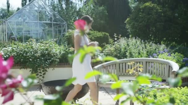 Frau entspannt sich bei einem Drink im Garten — Stockvideo