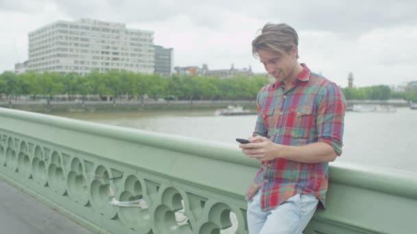 Человек с мобильным телефоном, стоящий рядом с Тамесом — стоковое видео