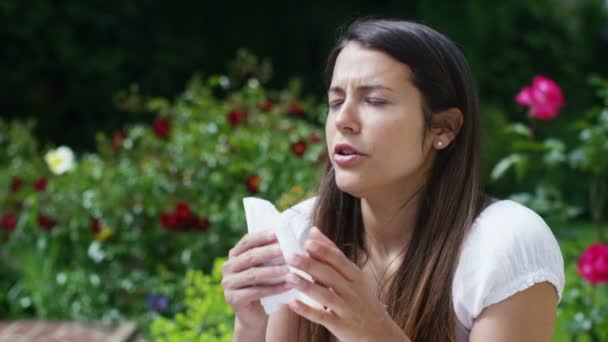 Mujer con fiebre del heno estornuda en un tejido — Vídeo de stock