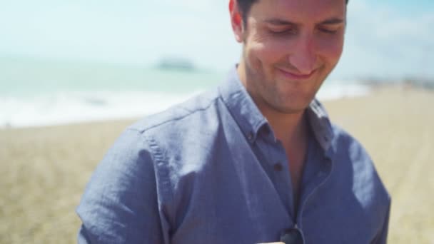 Hombre con teléfono móvil en la playa — Vídeo de stock