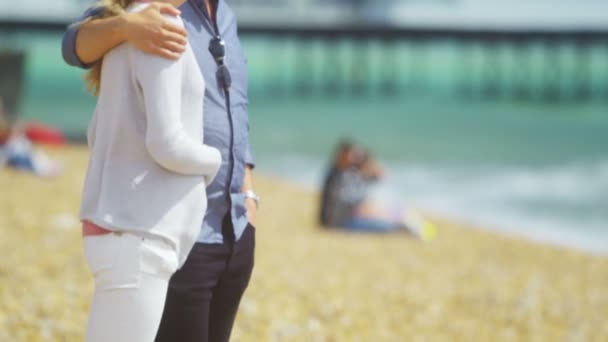 Пара на пляже, улыбающаяся в камеру — стоковое видео