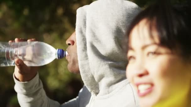 Чоловік і жінка п'ють з води — стокове відео