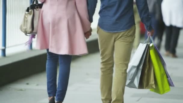 Paar mit Einkaufstüten hält Händchen — Stockvideo