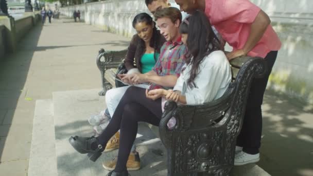 Amigos mirando tableta de la computadora al aire libre — Vídeo de stock