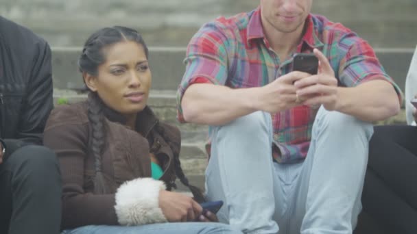 Freunde schauen im Freien auf Smartphones — Stockvideo