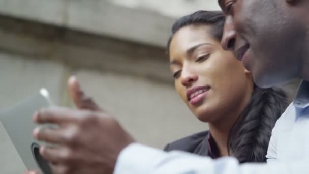 Couple utilisant une tablette numérique dans la ville 