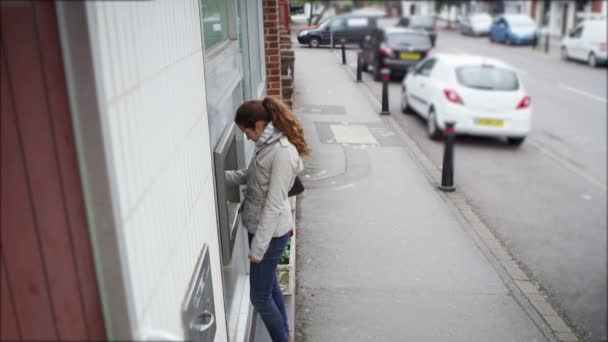 Kvinnan tar kontanter från en uttagsautomat. — Stockvideo
