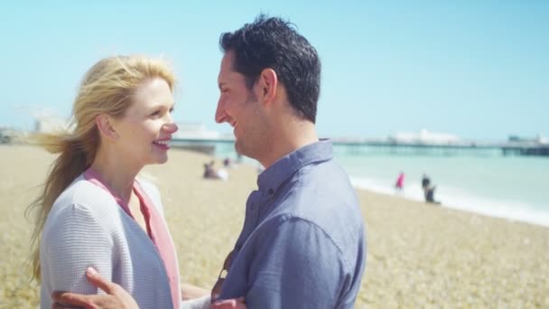 Pareja en la playa sonriendo a cámara — Vídeo de stock