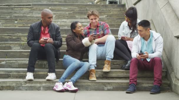 Amigos mirando todos los teléfonos inteligentes — Vídeo de stock