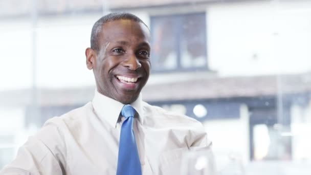 Un hombre de negocios sonriente en una reunión — Vídeos de Stock