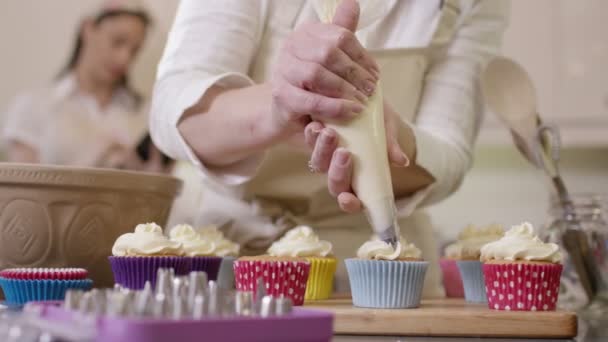 Mulher canalização creme em cupcakes — Vídeo de Stock