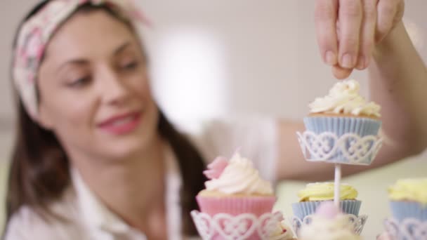 Vrouw zetten afwerking raakt op cupcakes — Stockvideo