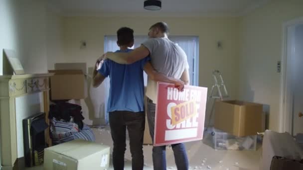 Гей пара стоит с табличкой "продано" — стоковое видео