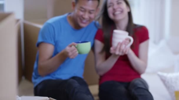 Couple take a coffee break from unpacking boxes — Stock Video