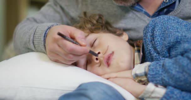 Father draws moustache on son — Stock Video