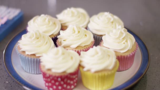 Espolvorear la parte superior de la mano sobre cupcakes — Vídeos de Stock