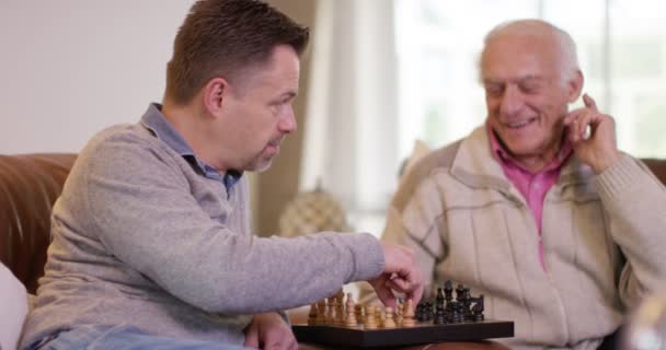 Senior homme jouant aux échecs avec son fils — Video